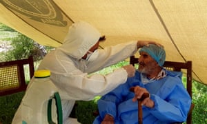 A paramedic wearing protective gear takes a nasal swab of 103 year-old Abdul Alim, to be tested for Covid-19, at the Aga Khan Health Services Emergency Response Centre in Booni, Chitral, Pakistan.
