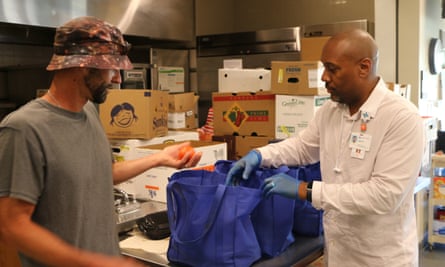 Two people packing food for distribution