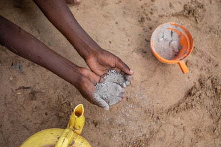 Ahmed Ali uses ash and soil to wash his hands outside his makeshift home at Xidig IDP camp in Mogadishu.