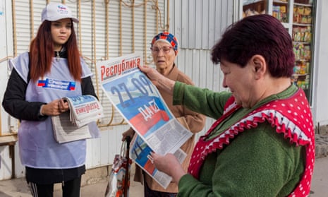 A volunteer distributes the Republic campaign newspaper with the slogan '27.09 – Yes' during a campaign rally for a referendum to join the Russian Federation in downtown Luhansk, Ukraine.