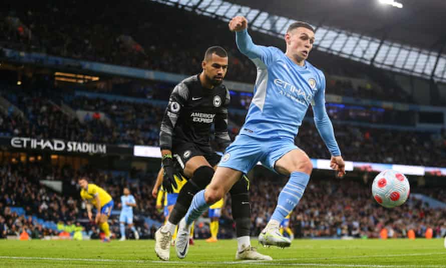 Phil Foden of Manchester City keeps the ball away from Brighton keeper Robert Sanchez.