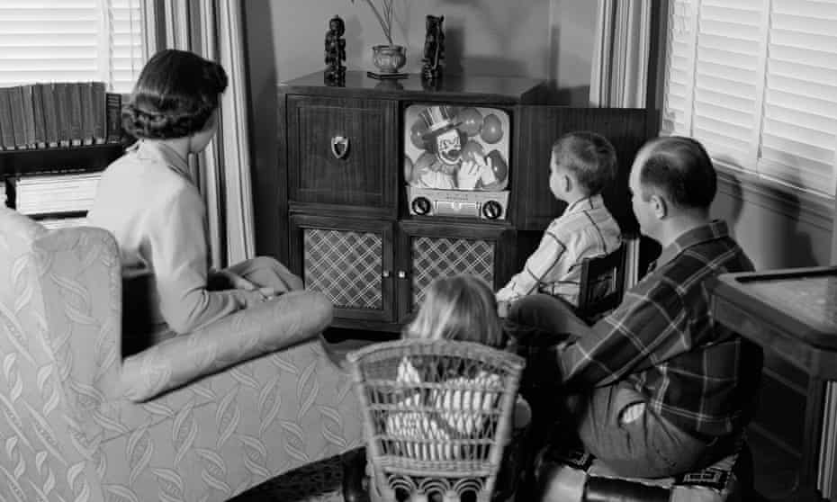 Nuclear family sitting in front of TV in 1950s
