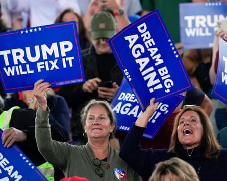 Trump supporters hold up signs that say 'Trump will fix it' and 'Dream big, again'