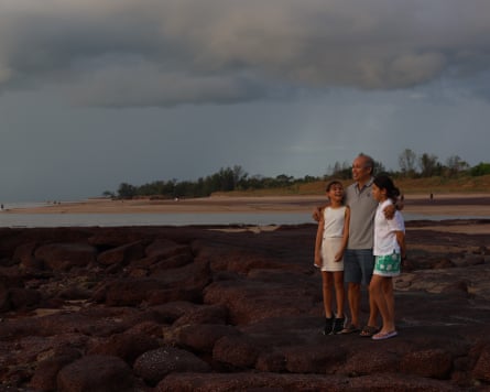 Lam Tac Tam walks along the rocky shore with his granddaughters, Mia and Mikaela Tutton, at Nightcliff beach 50 years after he first came ashore in a small fishing boat sailed from Vietnam. April 27 will mark 50 years since the first Vietnamese refugees began arriving in Darwin.
