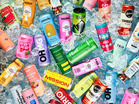 Lots of different cans of drink all lying flat on a bed of ice