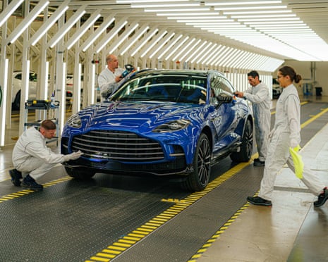 Os técnicos de pintura inspecionam o primeiro DBX 707 de produção, enquanto se prepara para deixar a fábrica Aston Martin St Athan, perto de Barry, País de Gales.