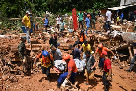 Rescue personnel transport the body of a victim after flooding in Barra do Sahy, São Sebastiao.