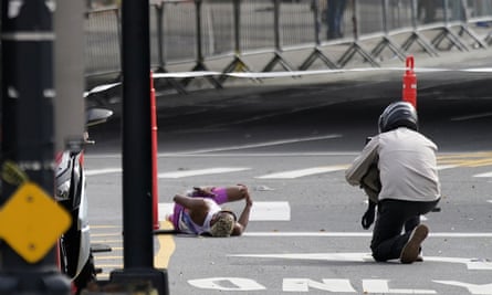 Daniel Do Nascimento lies on the pavement after collapsing five miles from the finish line.