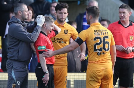 Calum Spence receives medical treatment during a game after being struck on the head by an object thrown from the crowd.