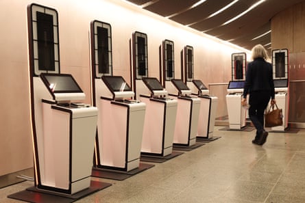 A woman walks towards a check-in kiosk