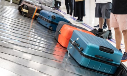 Baggage luggage at airport arrival carousel with passengers awiating to claim theirs