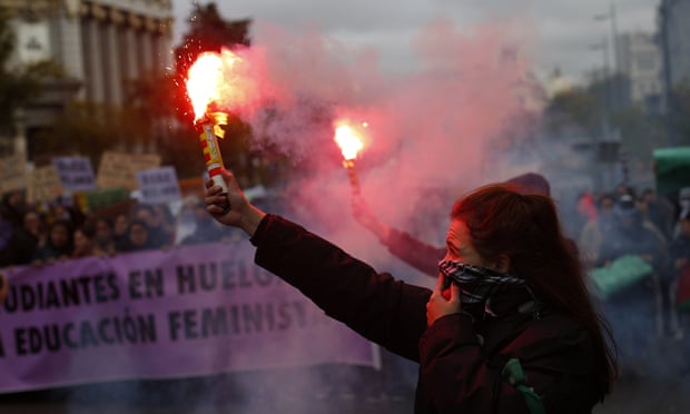 A woman burns a flare in Madrid.