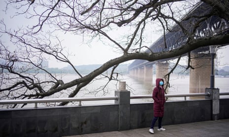 A woman walks under the Yangtze River Bridge in Wuhan