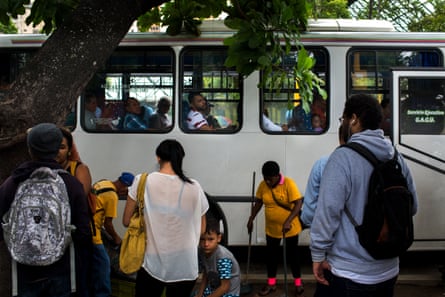 Passengers wait for a bus in Caracas, Venezuela.