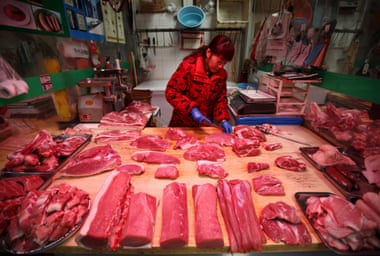 A butcher prepares cuts of pork at a market stall in Beijing, the Chinese capital.