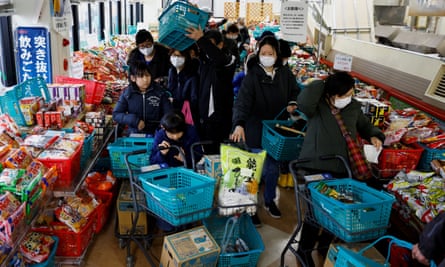 Residents queue to buy goods at a reopened Wajima supermarket damaged by Monday’s quake
