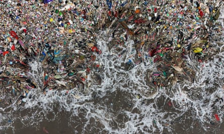 A drone view shows trash being swept to the shore in Teluk