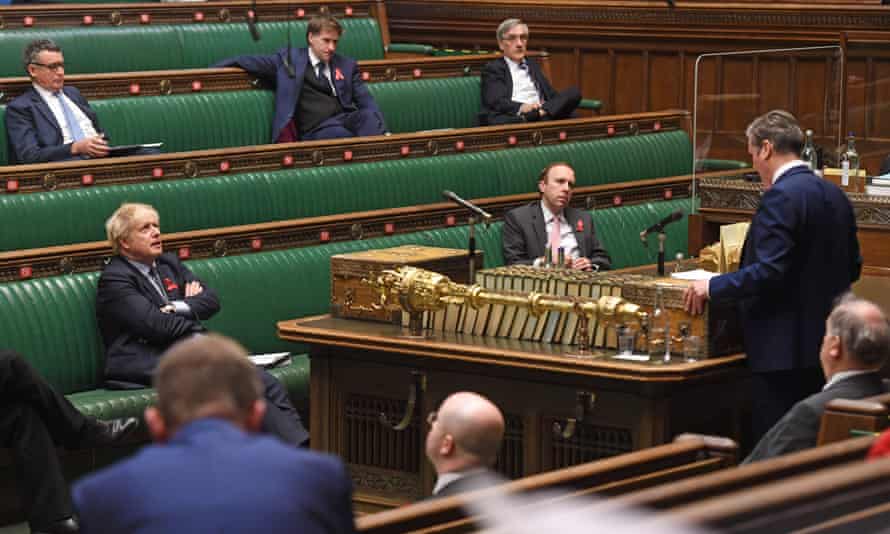 Boris Johnson listening as Labour’s Keir Starmer speaks in the Commons