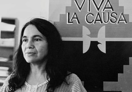a woman stands in front of a flag that says 'viva la causa'