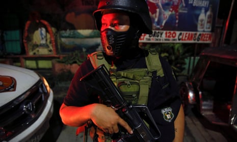 A member of the Philippines special police force stands guard in a street in Manila