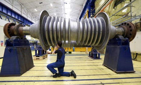 A worker inspects a power station turbine