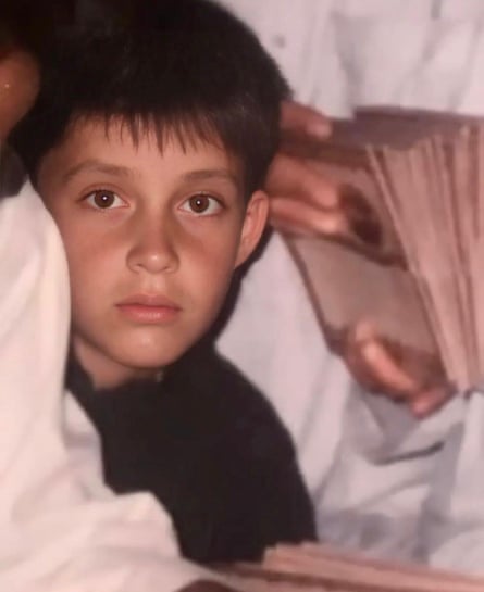 A young boy is shown posing for a photo with a serious expression