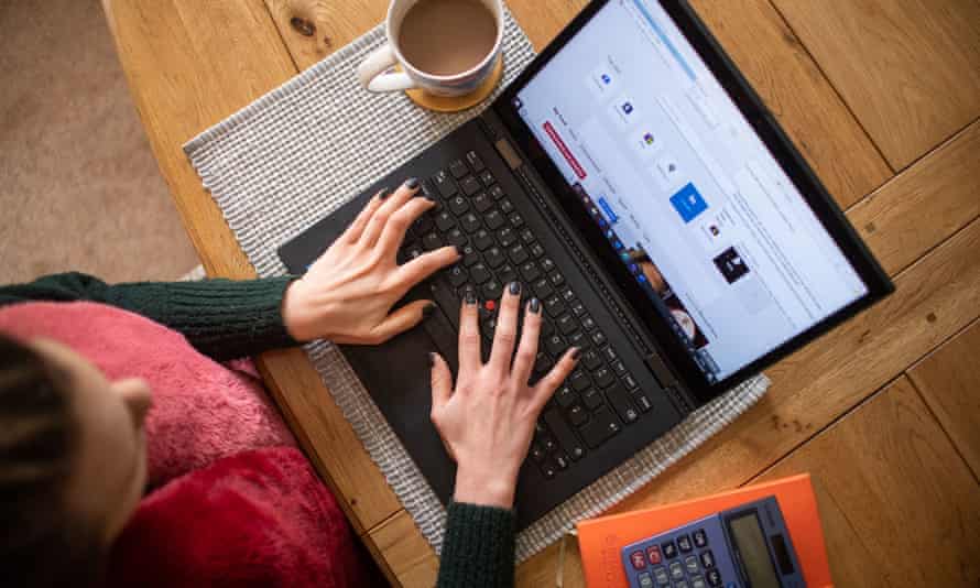 A woman works on a laptop from home