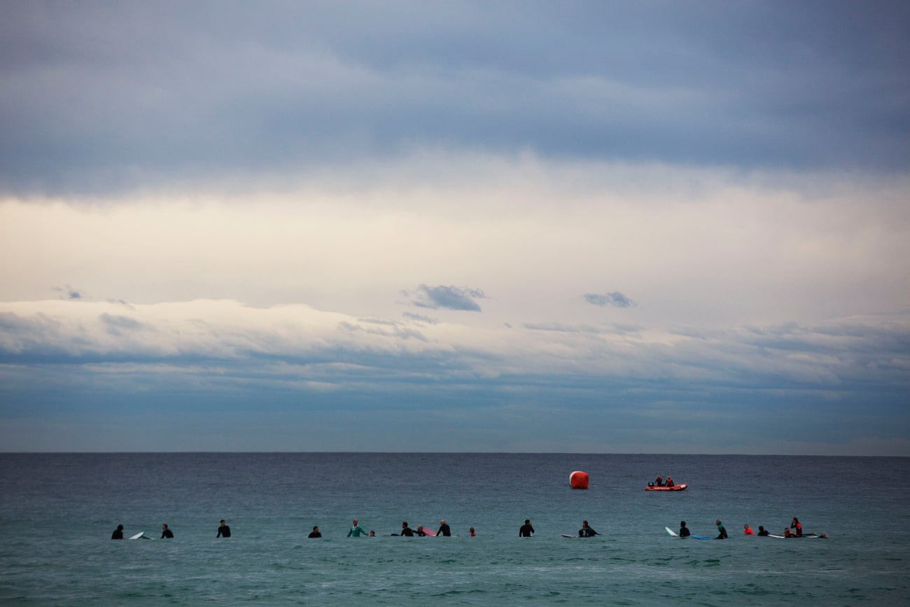 Surfers wait on the ocean on what looks like a normal sleepy morning at Bondi.