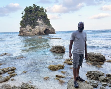 Devon Taylor stands on a stone at the shoreline