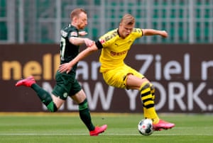 Dortmund’s wunderkind Erling Braut Haaland controls the ball as to Wolfsburg’s Maximilian Arnoldlooks on.