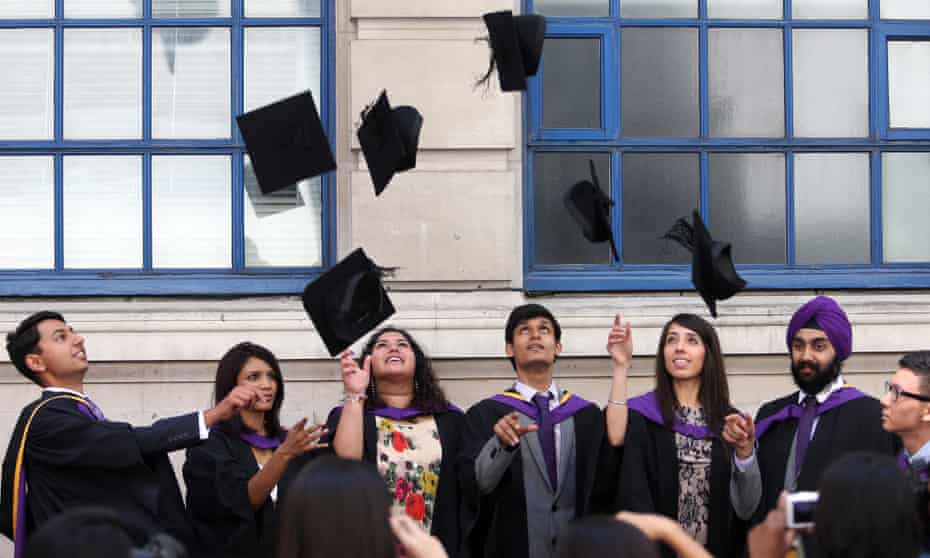 University students throw mortarboards in the air