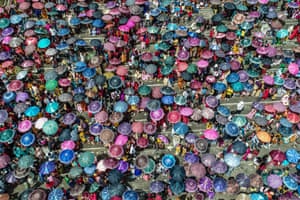 Spectators carrying umbrellas gather during the Behdienkhlam festival which is celebrated annually after the sowing season in the village of Tuber.