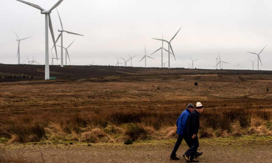 People walk past wind turbines on Eaglesham moor, south-west of Glasgow.