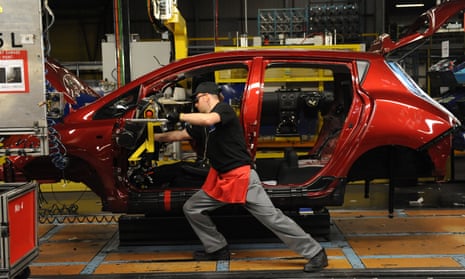 An employee works on a car production line
