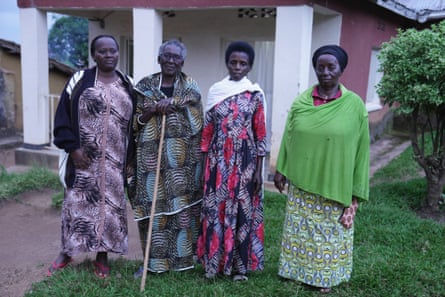 Four African women in tradition patterned dresses standing on a lawn
