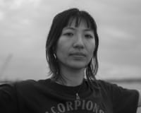 A black and white photo of a woman standing outside