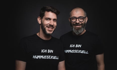Oz Ben David and Jalil Dabit, standing side by side and smiling and both wearing black t-shirts saying 'ich bin hummussexuell'