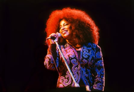 Chaka Khan sings while wearing a purple jacket and a bouffant hair-do.