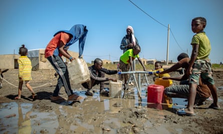 Refugees fill water bottles in Village 8 refugee settlement in Eastern Sudan.