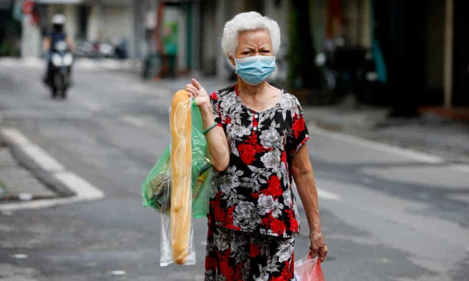 A woman carrying a baguette in Hanoi