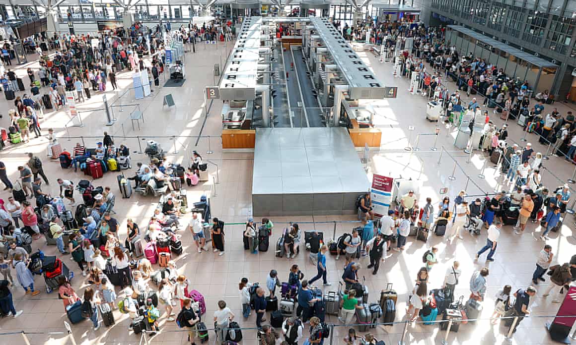 Travellers with their suitcases wait in Terminal 1 for check-in at Hamburg Airport in Hamburg, Germany.
