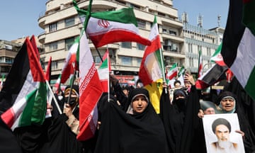 Iranian's wave the flags of Palestine and Iran after the Friday noon prayer in Tehran