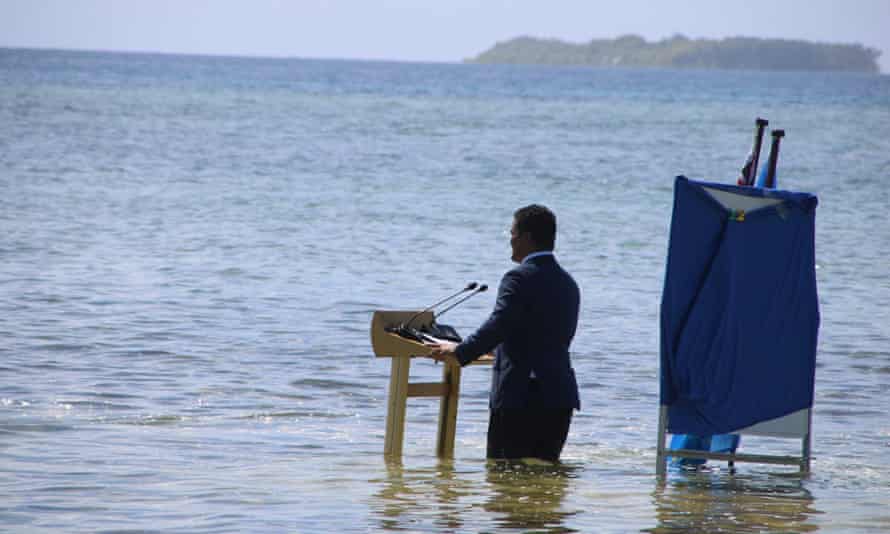 Tuvalu's foreign affairs Simon Kofe speaks while standing knee-deep in the ocean in Funafuti, Tuvalu