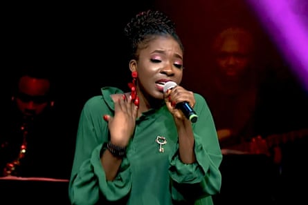 A young woman sings into a microphone.