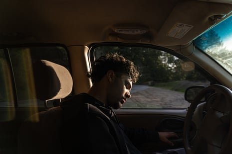 A man in a car in early evening light