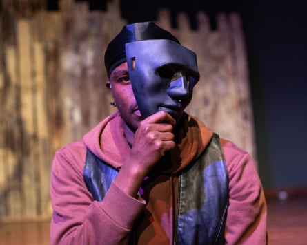 Tom Tobit holds a mask partly obscuring his face