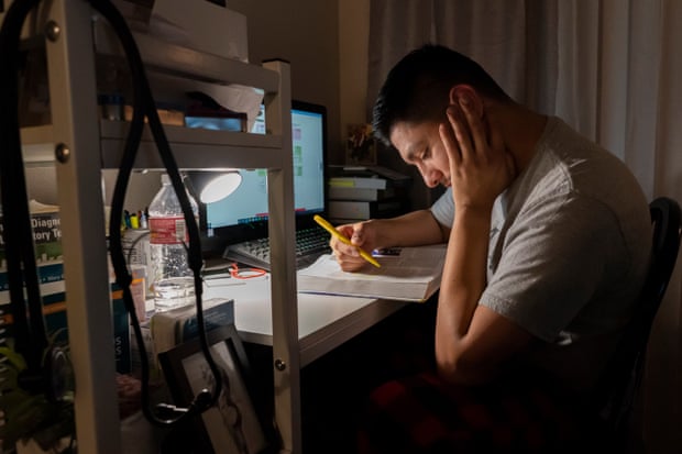 Miguel studies for his mid-term exams at his desk in his apartment.