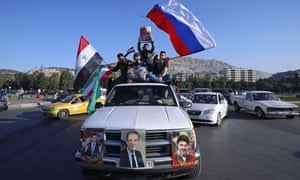 Syrian government supporters wave Syrian, Iranian and Russian flags as they chant slogans against U.S. President Trump during demonstrations following a wave of U.S., British and French military strikes
