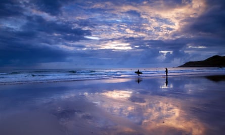 The Last SurfSurfers at sunset on Woolacombe beach, Devon, England.