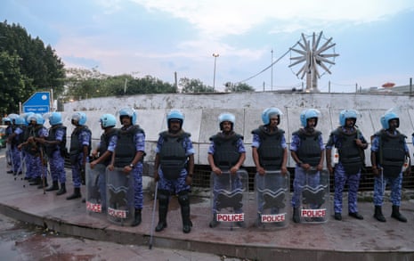 Officers stand guard in front of a concrete barricade